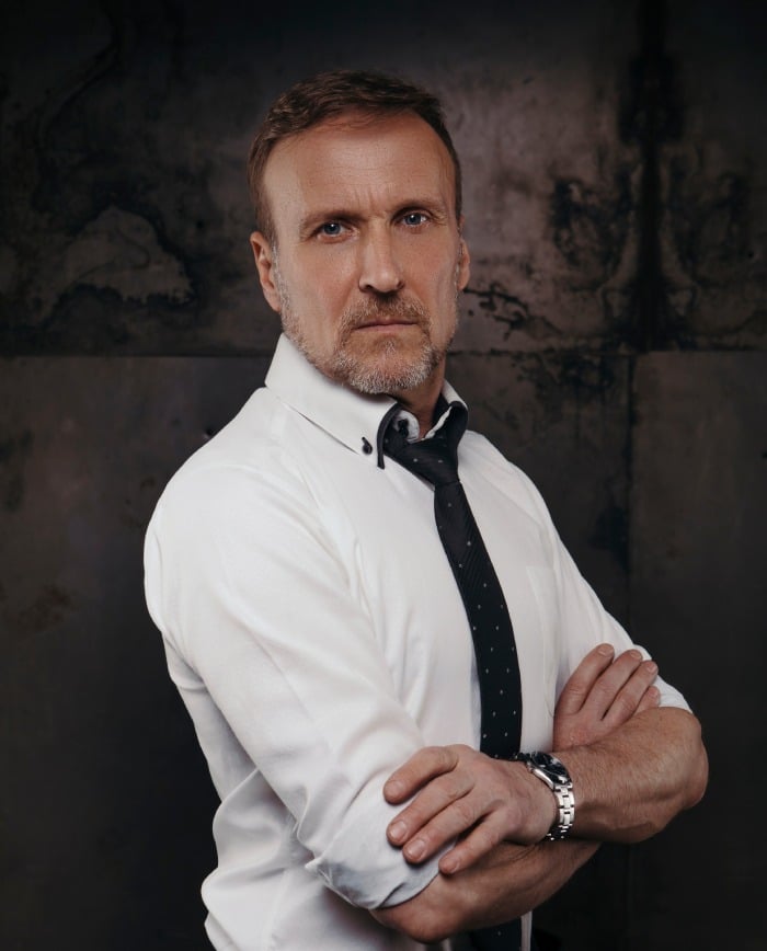 Old handsome business man in white shirt and tie on a grungy, dark background