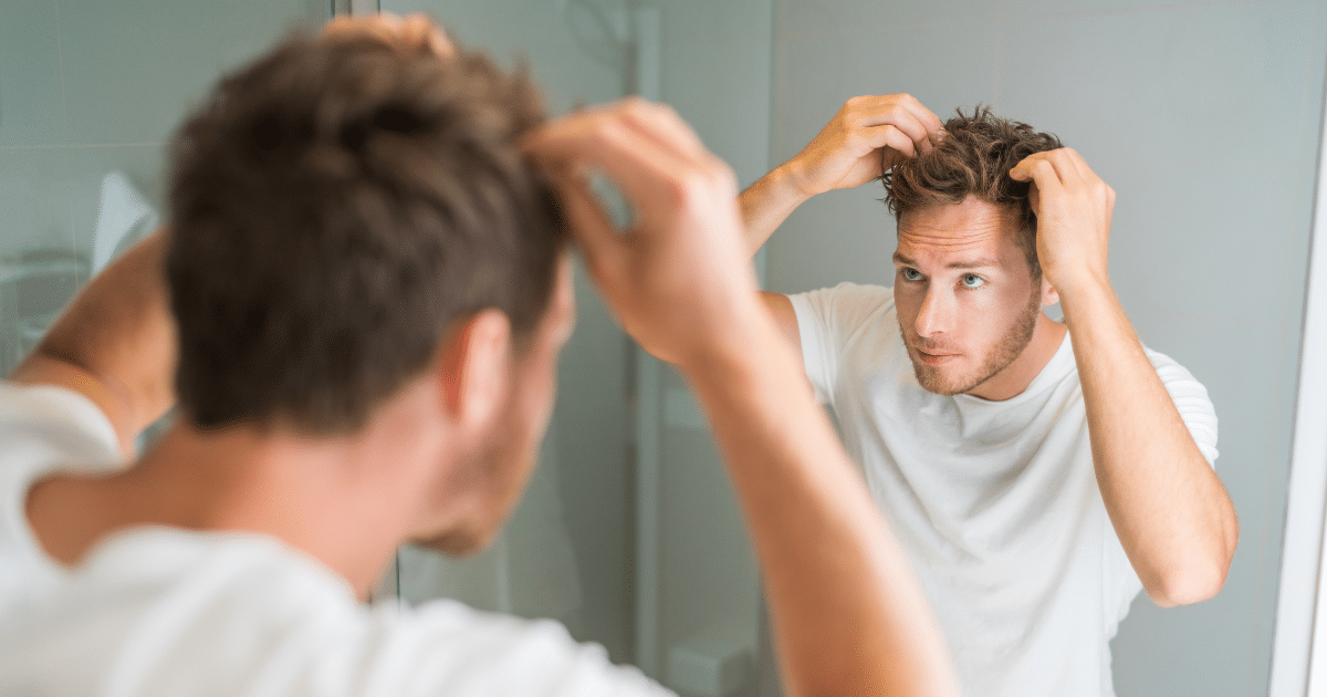 Imagen de un hombre examinando su cabello.